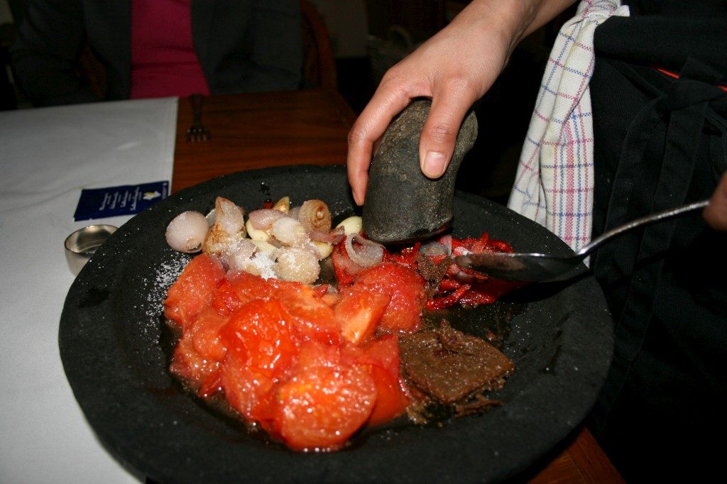 Tafelbereiding van sambal door chef Esther